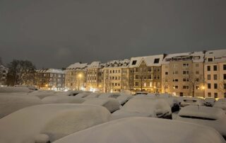 Onset of winter snow in Kiel on Blücherplatz on parked cars